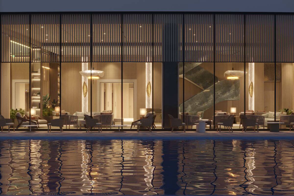 Glass-fronted poolside lounge at Shang Bauhinia Residences with warm lighting, elegant interiors, and water reflections